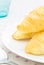 Croissant or Bread on White Dish on Placemat with Spoon and Glass Close up View