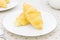 Croissant or Bread on White Dish on placemat with spoon and tea