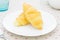 Croissant or Bread on White Dish on Placemat with Spoon and Tea