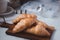 croissant on a brown plate next to a mug of milk on marble background