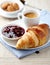 Croissant, cherry marmalade and a cup of coffee on a plate