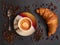 Croissant with Coffee cup and coffee beans on grey slate background. Top view