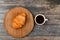 Croissant and a cup of coffee on the table. Fresh french croissant. on a wooden background. View from above. Morning breakfast