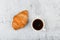 Croissant and cup. on a specific background. Fresh french croissant. on a wooden background. View from above. Morning breakfast