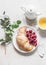 Croissant, fresh raspberries and green tea on a white background, top view. Delicious breakfast, dessert, snack