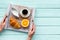 Croissant, fruit and coffee with cream for breakfast on the tray on mint green wooden background top view space for text