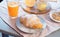 Croissant, honey jar and orange juice on wooden table. Healthy breakfast