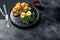 Croissant with hot smoked salmon, avacado, arugula and egg. Black background. Top view. Space for text