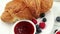 Croissant with jam and berries. Delicious and traditional breakfast