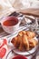 Croissant with jam and tea in the service tray close up image