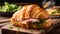 Croissant sandwich with ham, cheese and salad on wooden board