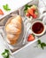 Croissant, tea and strawberries. Breakfast and morning concept