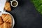 Croissants, coffee and sprouted wheat on a dark background.