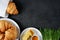 Croissants, honey, and sprouted wheat on a dark background.