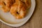 Croissants pastry in white dish on the wooden table.