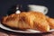 croissants saucer on the table fork with a knife fresh pastries