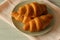 Croissants stacked on a plate with a pink tea towel