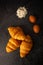 Croissants with white coffee cups with flour and eggs on a black background, breakfast, brown bread, morning drinks Concept: