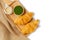 Croissants on wooden bread cutting board and sweetened condensed milk, green tea mug, with sackcloth over white background.