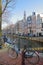 Crooked and colorful heritage buildings, located along Bloemgracht Canal, with Westerkerk church clocktower in the background