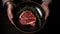 Crop anonymous person holding plate with piece of raw marbled beef steak with rosemary , generative AI tools