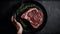 Crop anonymous person holding plate with piece of raw marbled beef steak with rosemary , generative AI tools