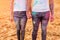 Crop couple with colorful clothes holding hands