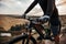 Crop cyclist riding bike in mountains