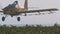 Crop duster spraying chemicals over a cotton field - slow motion