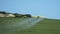 Crop duster spraying fertliizer over green crops