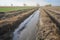 crop field with runoff flowing into nearby stream