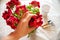 Crop gardener touching red flowers at home