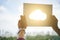 Crop hands holding cloud cutout against sunlight