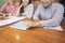 Crop happy coworkers with tablet at desk