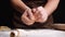 Crop housewife tearing dough over table