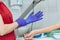 Crop image of nurse putting on blue medical glove for blood sampling