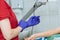 Crop image of nurse putting on blue medical glove for blood sampling