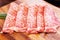 Crop image of Premium Rare Slices Wagyu A5 beef with high-marbled texture on square wooden plate served for Sukiyaki and Shabu