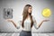 Crop image of young attractive businesswoman, hands at sides, levitating locked money vault and huge golden coin.