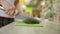 Crop man chopping herbs on cutting board in kitchen