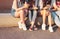 Crop photo of group of young happy girls real friends students using mobile at city street on sunset background