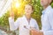 Crop scientist wearing lab coat while examining tomatoes growing in greenhouse