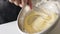 Crop shot of woman preparing homemade omelette mixing with whisk eggs.