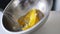 Crop shot of woman preparing homemade omelette mixing with whisk eggs.