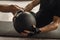 Crop sportsman exercising with medicine ball in gym