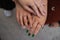 Crop of three girls showing her stylish manicure, holding their fingers on black leather handbag. Different design of