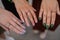 Crop of three girls showing her stylish manicure, holding their fingers on black leather handbag. Different design of