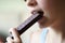 Crop unrecognizable teenage girl eating healthy protein bar