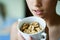 Crop unrecognizable teenage girl holding fresh walnuts in cup