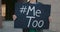 Crop view of hands holding banner with Metoo hashtag on it. Female activist endorsing protest against sexual assault